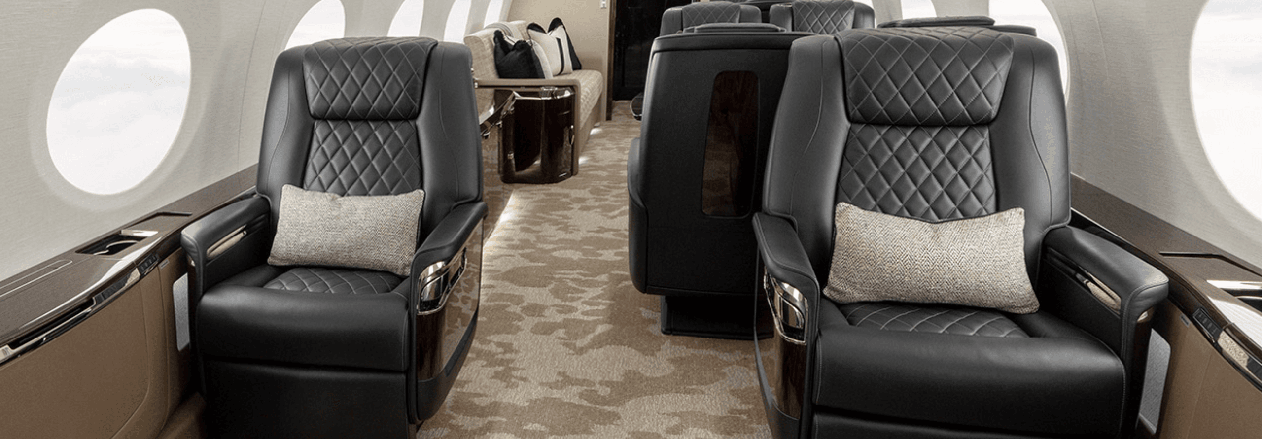 Spacious private jet cabin with black leather seats