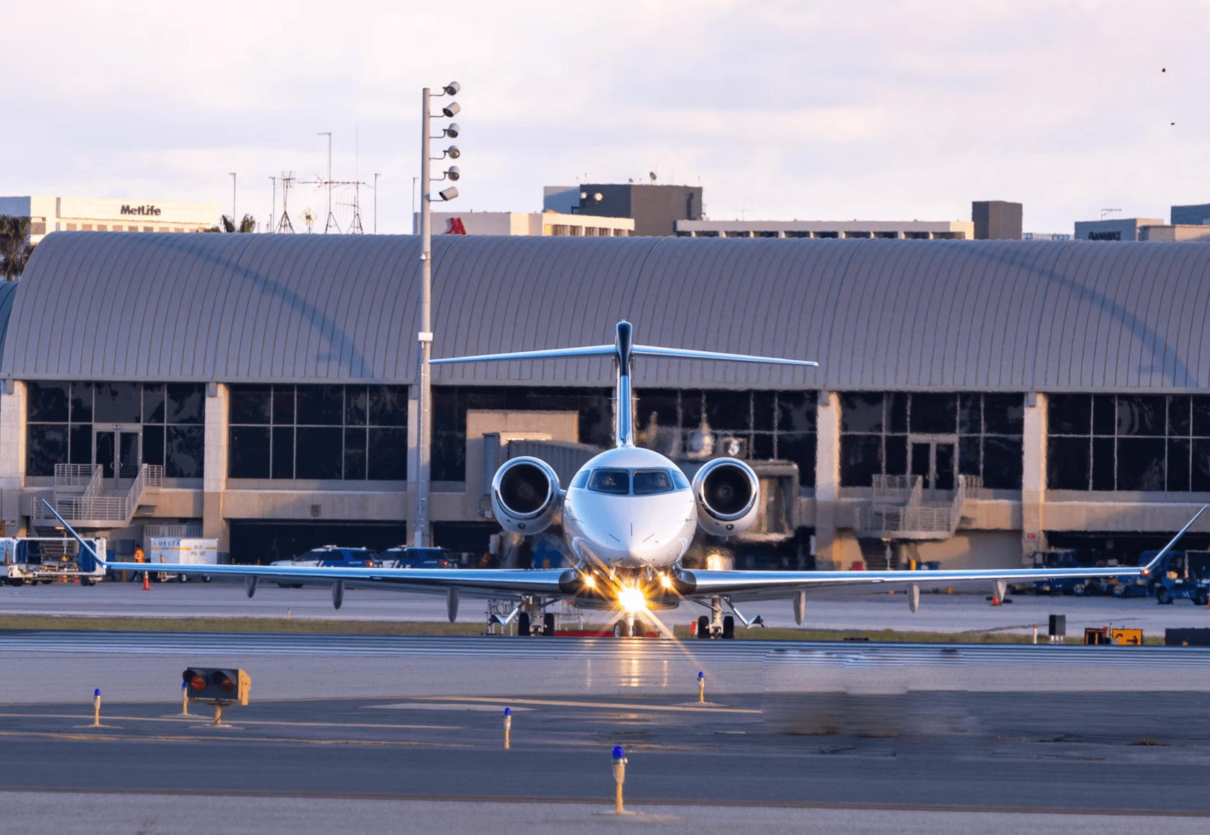 Private jet facing forward on the ramp in front of an airport hangar