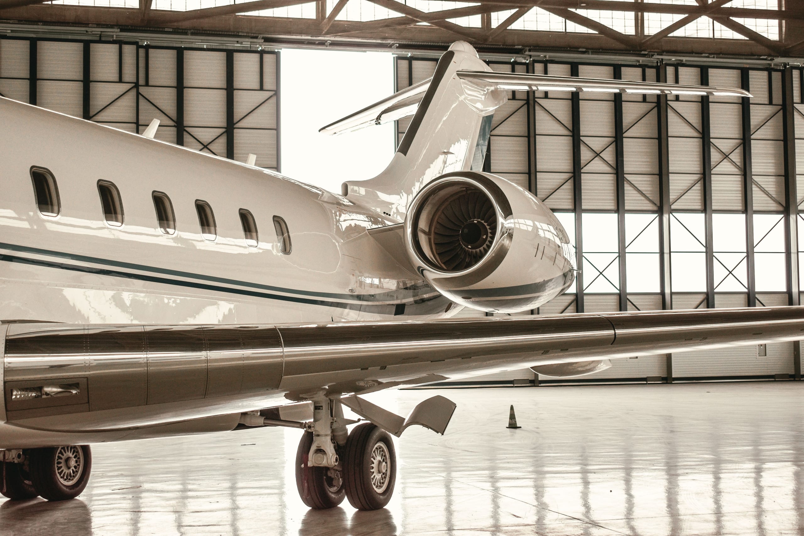 Private jet parked inside a hangar with large open doors