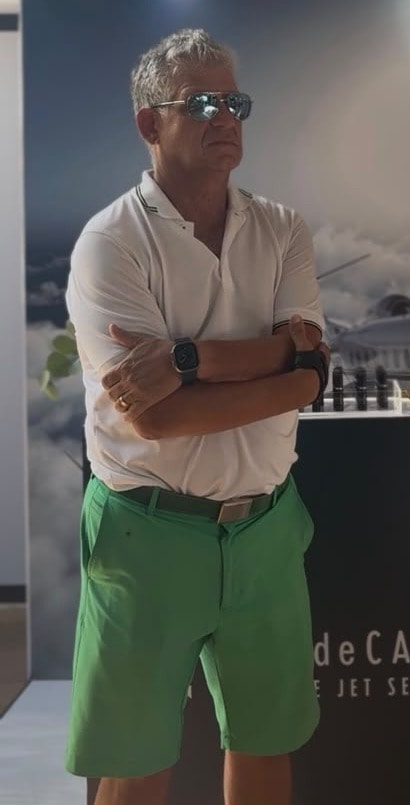 Mr. Zuckerman standing with his arms crossed in front of the Casa de Campo Private Jet Service booth